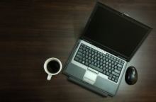 Typisches Arbeitsgerät: Laptop und eine Tasse Kaffee